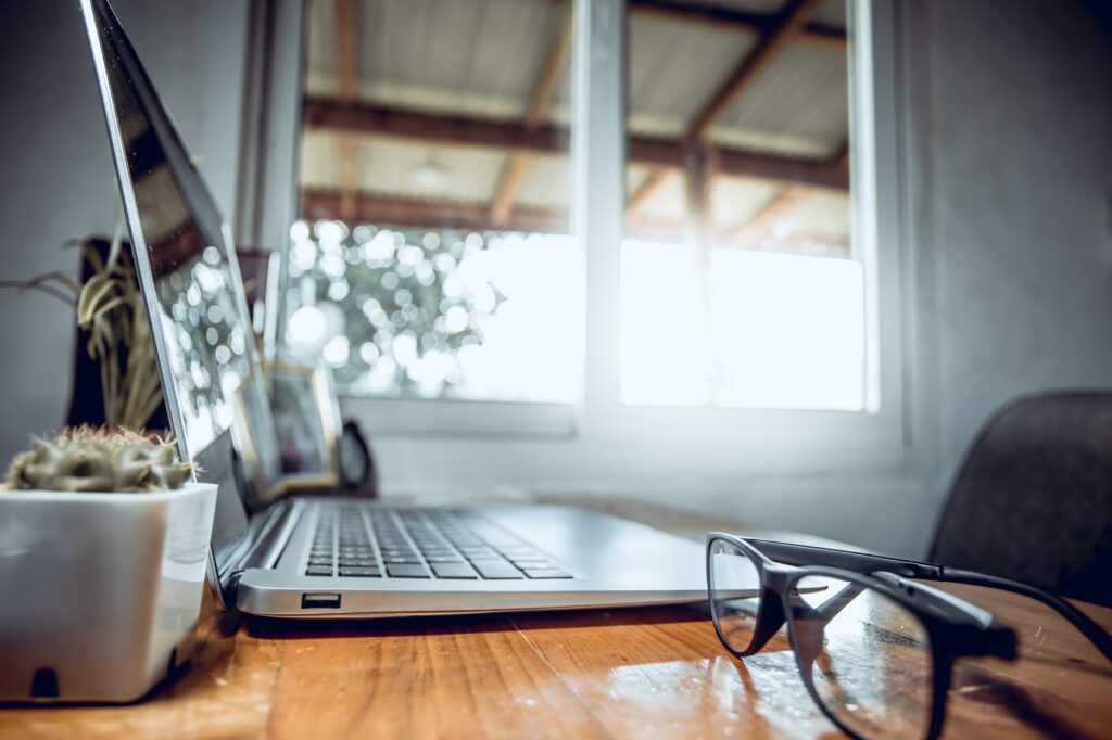 Close up eye glasses with laptop computer on desk, Work from home, Business concept.